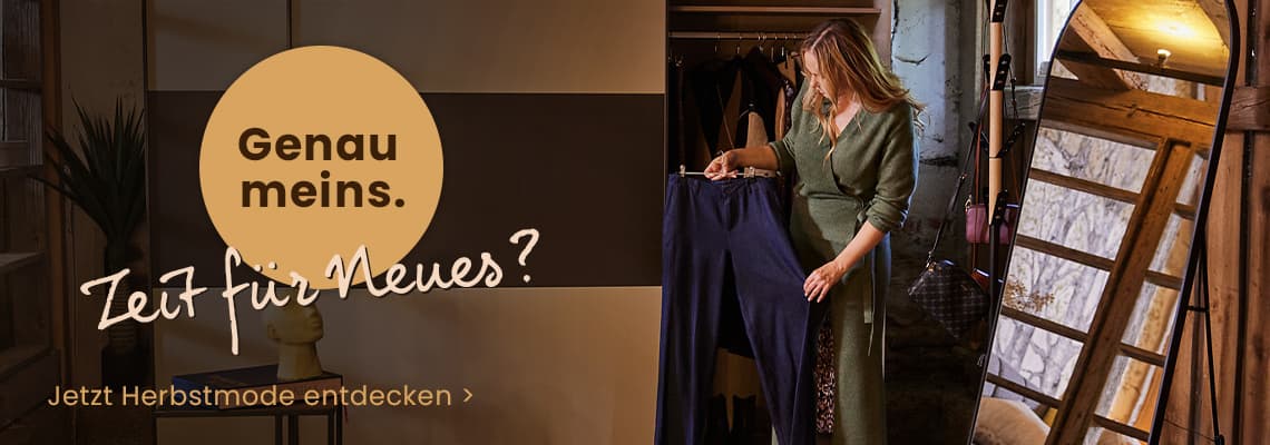Genau meins. Zeit für Neues? – Frau im langen Kleid hält Hose vor dem Kleiderschrank, Text: Jetzt Herbstmode entdecken