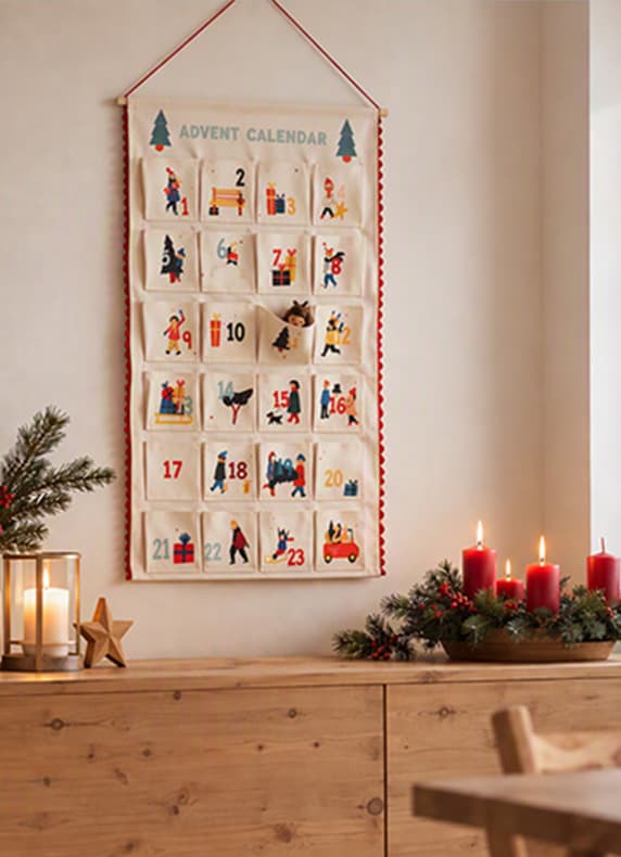 ADVENT CALENDAR – hängender Adventskalender mit nummerierten Taschen, davor Holzkommode mit Kerzen und Tannendeko