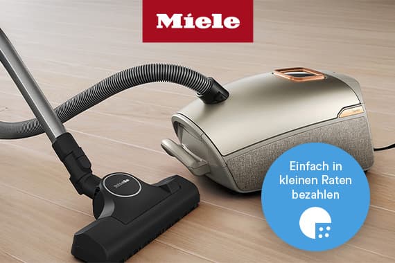 Einfach in kleinen Raten bezahlen – Miele Bodenstaubsauger mit Schlauch und Bodendüse auf hellem Holzboden