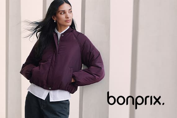 Frau in dunkler Jacke und Hemd lehnt an Säule, schaut zur Seite, bonprix Logo rechts unten